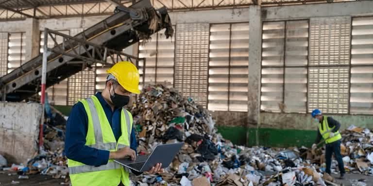 Gestión de residuos industriales en San Cristóbal con supervisión digital de inventarios de materiales reciclables frente a una montaña de desechos mixtos.