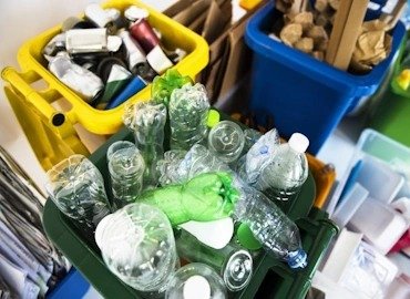 Contenedores de reciclaje con envases plásticos PET seleccionados para la gestión de residuos sólidos en Bogotá.