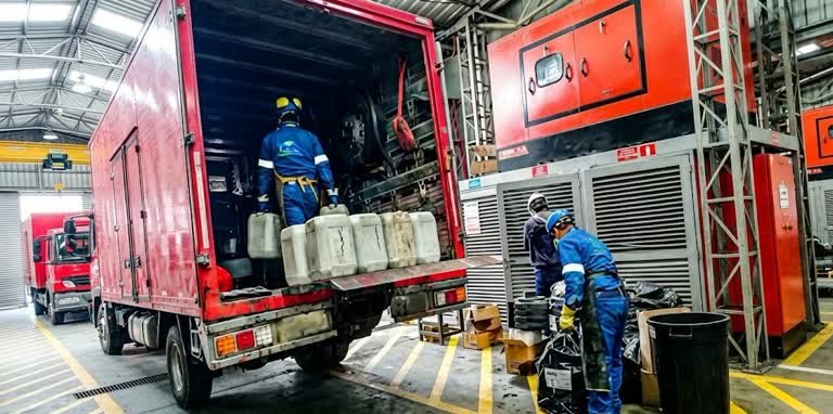 Gestión de residuos industriales en San Cristóbal durante el proceso de carga de bidones y recipientes de materiales químicos en vehículos de transporte.